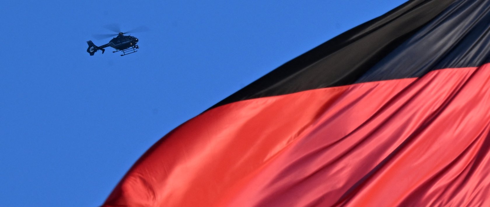 A helicopter of the German police is seen hovering over a German national flag at the Reichstag building that houses the Bundestag (lower house of parliament) in Berlin, Germany, Dece. 15, 2025. (AFP Photo)