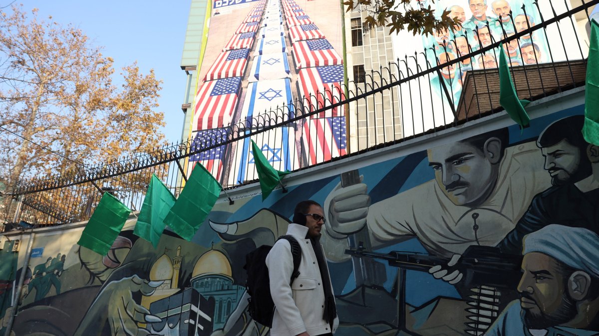 An Iranian man walks next to an anti-U.S. and Israeli billboard, Tehran, Iran, Jan. 4, 2026. (EPA Photo)
