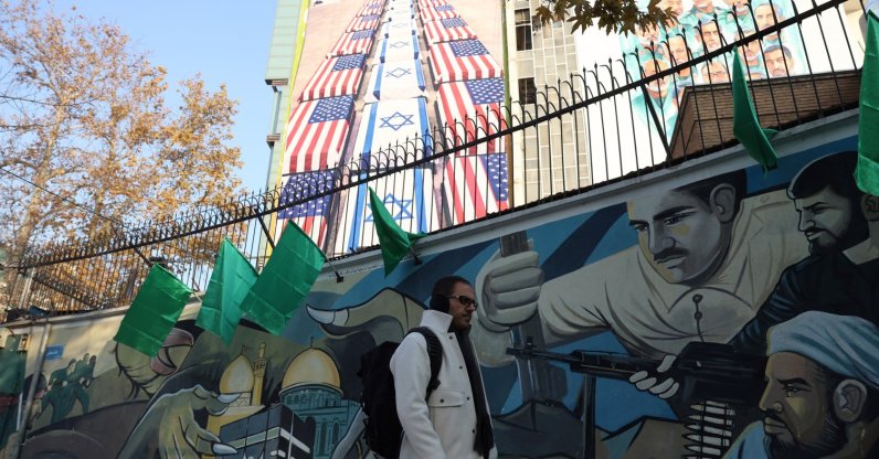 An Iranian man walks next to an anti-U.S. and Israeli billboard, Tehran, Iran, Jan. 4, 2026. (EPA Photo)