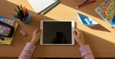 A student uses a tablet at her desk at home. (Shutterstock Photo)