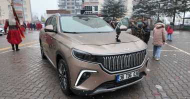 Students are seen close to a Togg model, inspecting it as part of "domestic products week," Kayseri, central Türkiye, Dec. 17, 2025. (IHA Photo)