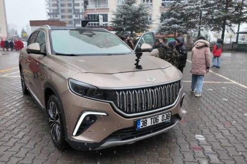 Students are seen close to a Togg model, inspecting it as part of "domestic products week," Kayseri, central Türkiye, Dec. 17, 2025. (IHA Photo)