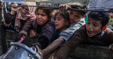 Palestinians, mainly children, wait to get hot food distributed by a charity organization at the al-Mawasi district, Khan Yunis, Gaza, Palestine, Jan. 7, 2026. (AA Photo)
