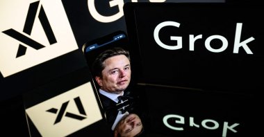 Screens display the logo of Grok, a generative AI chatbot developed by xAI, and its founder, Elon Musk, Toulouse, France, Jan. 13, 2025. (AFP Photo)
