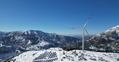 Wind turbines and a solar plant are seen in a snow-covered area with a backdrop of the Amanos Mountains, Osmaniye, southeastern Türkiye, Jan. 3, 2026. (AA Photo)