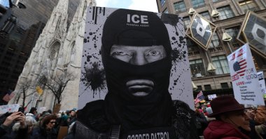 A protester holds a sign depicting Donald Trump as an ICE agent during a demonstration organized by Rise and Resist against US Immigration and Customs Enforcement (ICE) activities and the U.S. intervention in Venezuela, New York, U.S., Jan. 11, 2026. (AFP Photo)