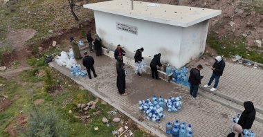 People fill up water jugs at a public fountain, Ankara, Türkiye, Dec. 22, 2025. (IHA Photo)