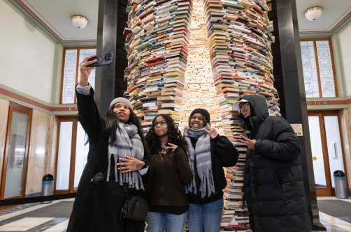 Tourists take a selfie in front of the 'Idiom' art installation made from 8000 books by Slovak artist Matej Kren which is placed in the foyer of the Central Library in Prague, Czech Republic, Jan. 7, 2026. (AFP Photo)