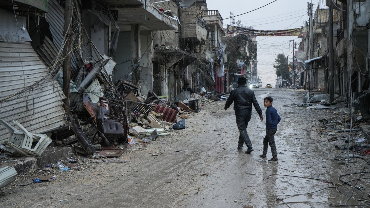 People walk on a street amid rubble following clashes between the YPG and the Syrian army, Aleppo, Syria, Jan. 11, 2026. (EPA Photo)