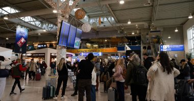 People look at flight information boards as airports across Greece suspended arrivals and departures, after unspecified issues affecting radio frequencies, Eleftherios Venizelos International Airport, Athens, Greece, Jan. 4, 2026. (Reuters Photo)