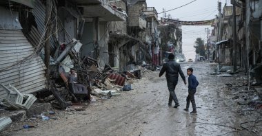 People walk on a street amid rubble following clashes between the YPG and the Syrian army, Aleppo, Syria, Jan. 11, 2026. (EPA Photo)