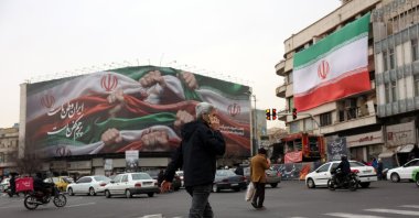 Iranians walk next to a billboard reading 'Iran is our Homeland' at Enqelab Square, Tehran, Iran, Jan. 13, 2026. (EPA Photo)