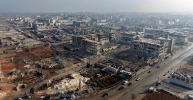 An aerial photograph shows buses as they enter from the Lairamoun roundabout toward the Sheikh Maqsud neighborhood, to evacuate the U.S.-backed YPG terrorists from two districts of the city of Aleppo, northern Syria, Jan. 9, 2026. (AFP Photo)