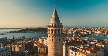 The Galata Tower at sunrise, with the sea and surrounding city buildings visible in the background. (Shutterstock Photo)