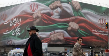Iranians walk next to a billboard reading 'Iran is our Homeland' at Enqelab Square in Tehran, Iran, Jan. 13, 2026. (EPA Photo)