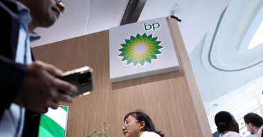 People walk past a BP logo during the annual energy industry event Abu Dhabi International Petroleum Exhibition and Conference (ADIPEC), Abu Dhabi, United Arab Emirates (UAE), Nov. 3, 2025. (Reuters Photo)