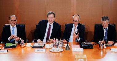 German Chancellor Friedrich Merz (3-L) touches German Finance Minister Lars Klingbeil (2-L) next to German Interior Minister Alexander Dobrindt (L) and German Chief of Staff at the Chancellery Thorsten Frei (R) as they pose with the 2 Euro commemorative coin 'Konrad Adenauer'  during the beginning of a meeting of the German government's cabinet in Berlin, Germany, Jan. 14, 2026. (EPA Photo)