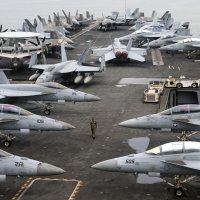A U.S. Navy officer walks past fighter jets on the flight deck of the Nimitz-class aircraft carrier USS Abraham Lincoln during a media tour, in Port Klang, outskirts of Kuala Lumpur, Malaysia, Nov. 24, 2024. (EPA File Photo)