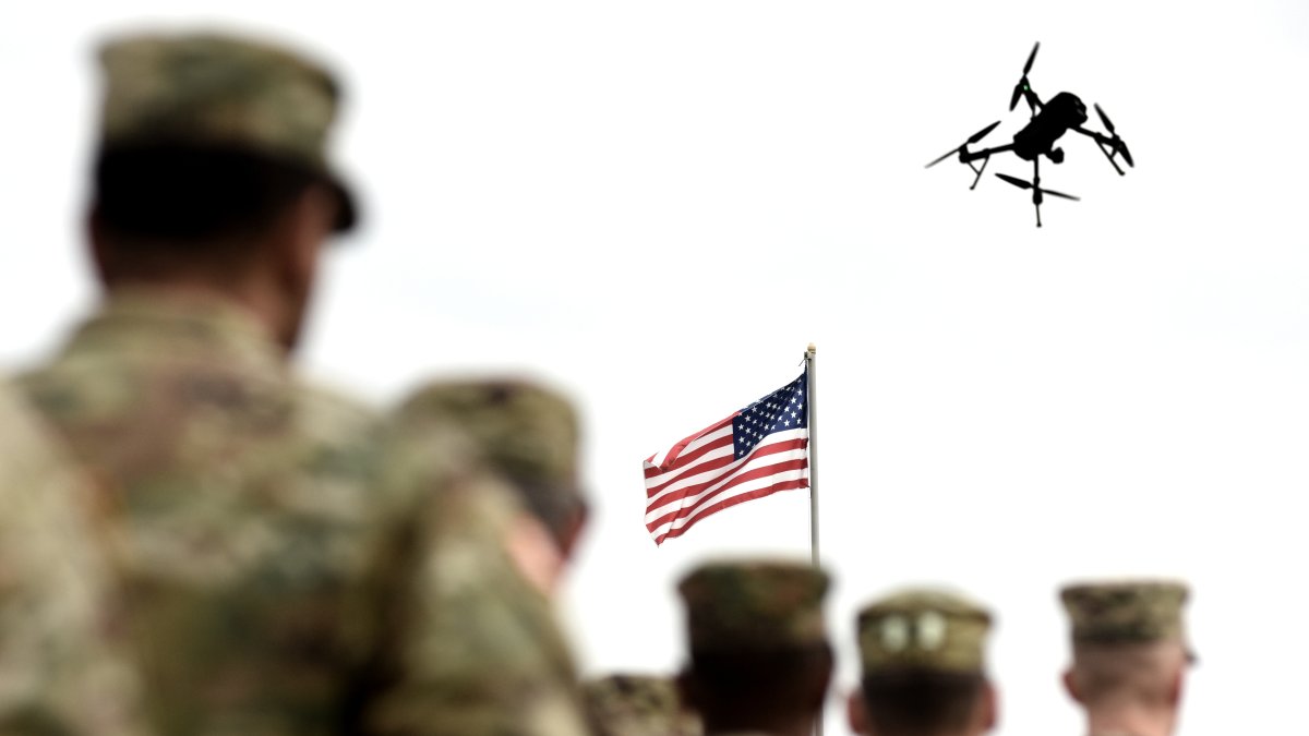 This photo shows American soldiers standing while a drone flyies in the sky. (Shutterstock Photo)