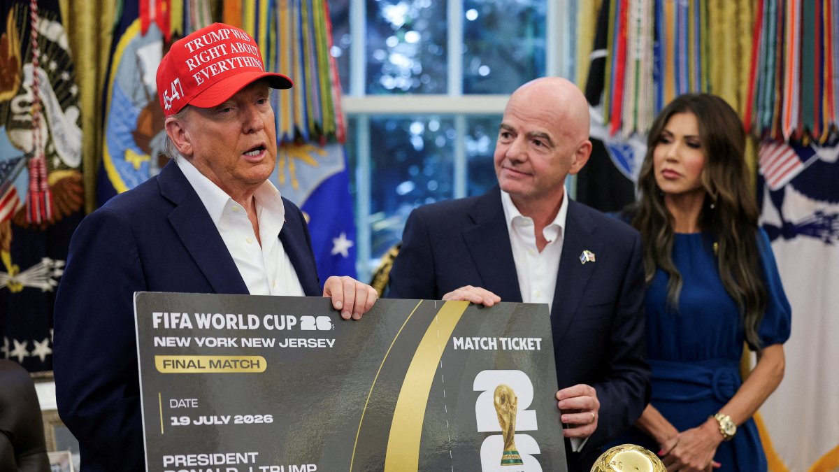 U.S. President Donald Trump (L) and FIFA president Gianni Infantino (C) hold a 2026 FIFA World Cup final match ticket in the Oval Office at the White House, Washington, U.S., Aug. 22, 2025. (Reuters Photo)
