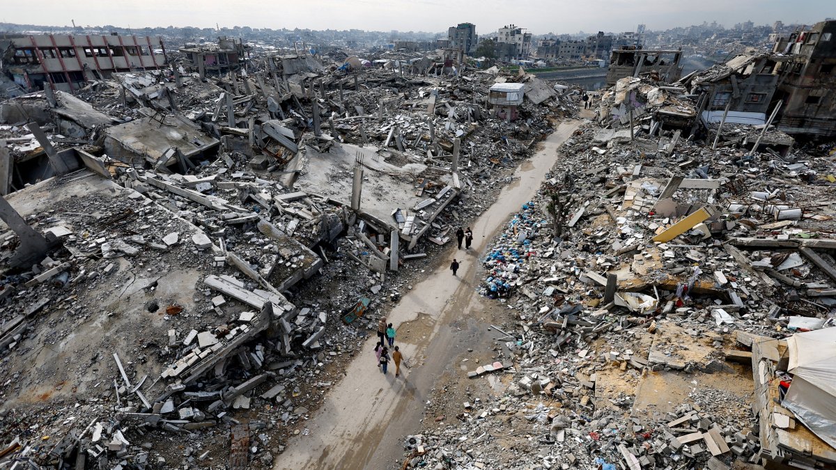 Palestinians walk past the rubble of residential buildings destroyed by Israeli strikes, Jabalia, northern Gaza Strip, Dec. 31, 2025. (Reuters Photo)