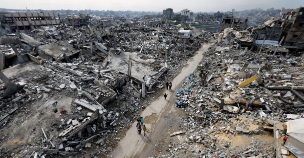 Palestinians walk past the rubble of residential buildings destroyed by Israeli strikes, Jabalia, northern Gaza Strip, Palestine, Dec. 31, 2025. (Reuters Photo)