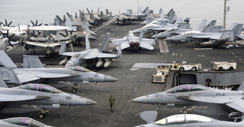 A U.S. Navy officer walks past fighter jets on the flight deck of the Nimitz-class aircraft carrier USS Abraham Lincoln during a media tour, in Port Klang, outskirts of Kuala Lumpur, Malaysia, Nov. 24, 2024. (EPA File Photo)