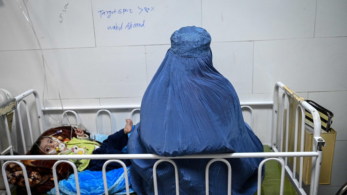 An Afghan woman sits next to her malnourished child inside the Medecins Sans Frontieres (MSF) therapeutic nutrition center at a hospital, Herat, Afghanistan, Jan. 8, 2026. (AFP Photo)