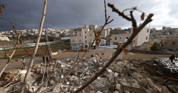 Relatives of Emran al-Atras, a Palestinian man who was killed in November, stand next to the rubble of his house after it was demolished by Israeli authorities in the Israeli-occupied West Bank city of Hebron, Jan. 15, 2026. (AFP Photo)