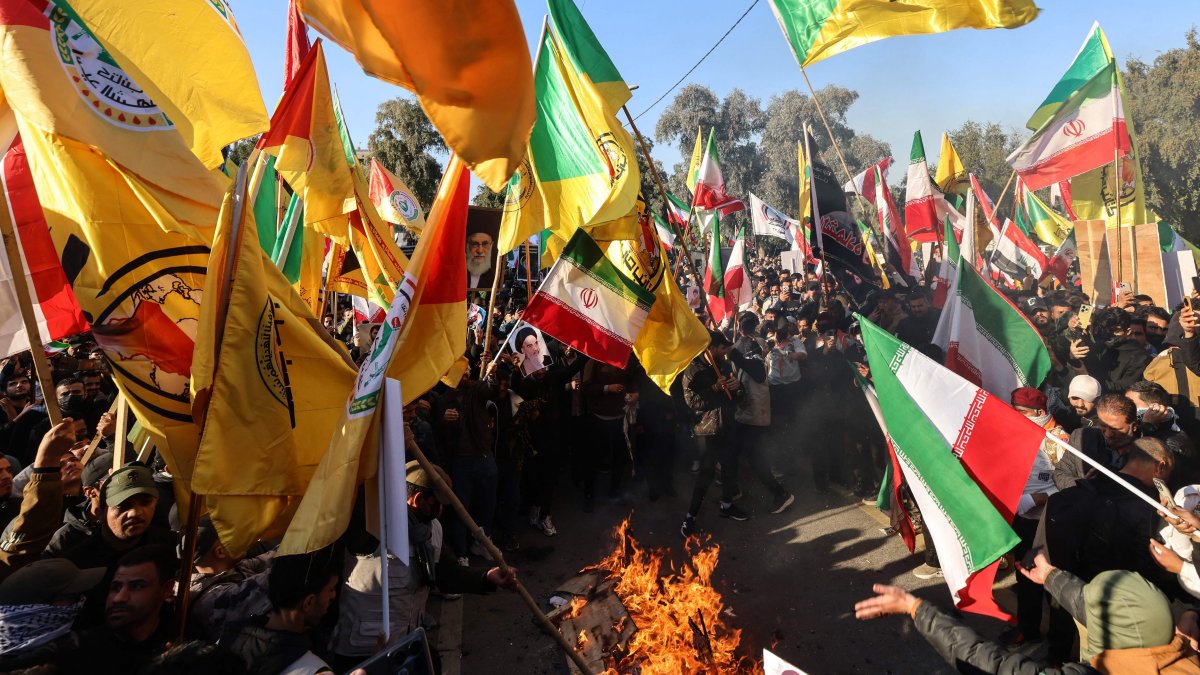 Protesters wave Iranian flags, along with flags of Iraqi armed factions loyal to Iran, as they burn U.S. and Israeli flags during a demonstration against Israel and recent U.S. threats of military action in Iran, and in support of the Iranian government and its supreme leader, near the Iranian embassy in Baghdad, Iraq, Jan. 16, 2026. (AFP Photo)