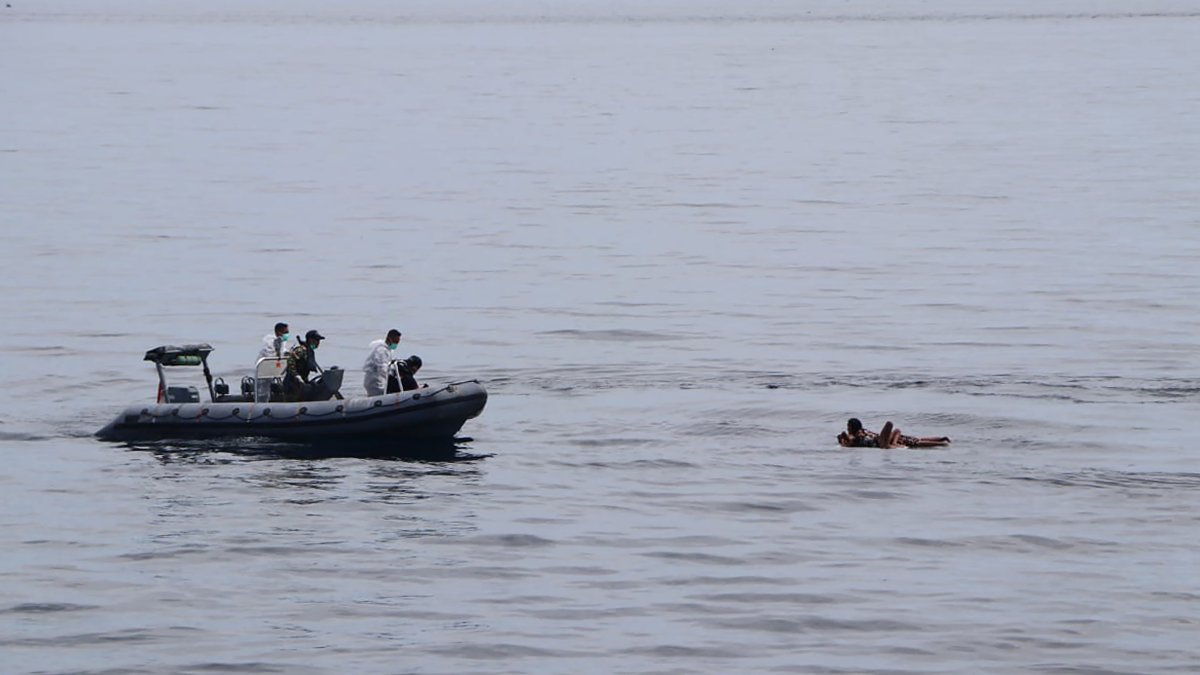 In this photo released by the National Search and Rescue Agency (BASARNAS), rescuers retrieve survivors floating on a wooden plank during a search for victims of a sinking cargo boat in the Makassar Strait, Indonesia, May 29, 2022. (AP Photo)