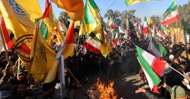 Protesters wave Iranian flags, along with flags of Iraqi armed factions loyal to Iran, as they burn U.S. and Israeli flags during a demonstration against Israel and recent U.S. threats of military action in Iran, and in support of the Iranian government and its supreme leader, near the Iranian embassy in Baghdad, Iraq, Jan. 16, 2026. (AFP Photo)
