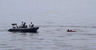 In this photo released by the National Search and Rescue Agency (BASARNAS), rescuers retrieve survivors floating on a wooden plank during a search for victims of a sinking cargo boat in the Makassar Strait, Indonesia, May 29, 2022. (AP Photo)