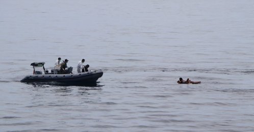 In this photo released by the National Search and Rescue Agency (BASARNAS), rescuers retrieve survivors floating on a wooden plank during a search for victims of a sinking cargo boat in the Makassar Strait, Indonesia, May 29, 2022. (AP Photo)