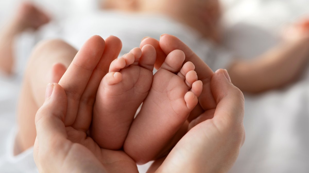 Tiny newborn baby feet gently held in a mother’s hands. (Shutterstock Photo)