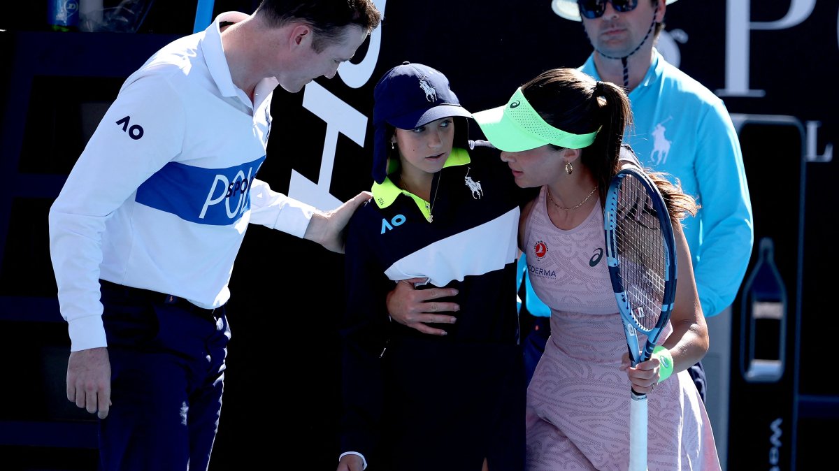 Türkiye's Zeynep Sönmez assists a ball kid after she fainted during Sönmez’s women’s singles match against Russia’s Ekaterina Alexandrova, Melbourne, Australia, Jan. 18, 2026. (AFP Photo)