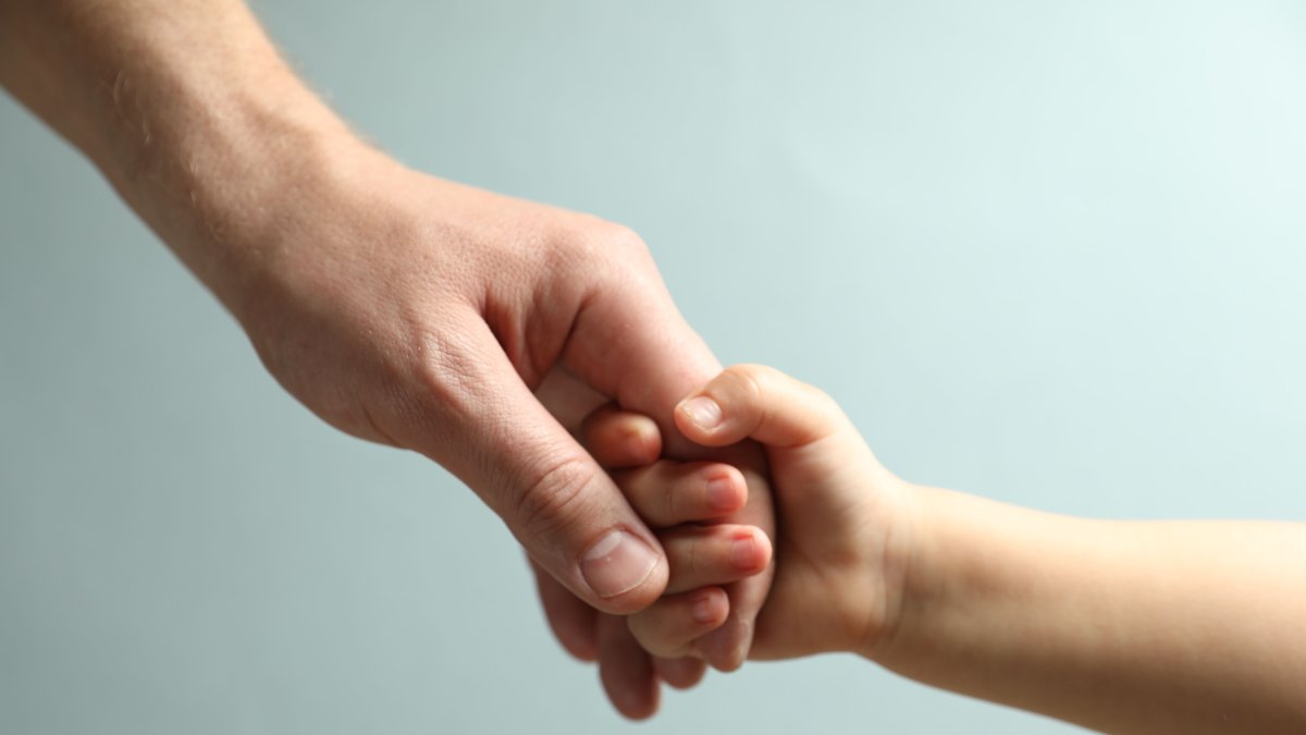 A father and child holding hands. (Shutterstock Photo)
