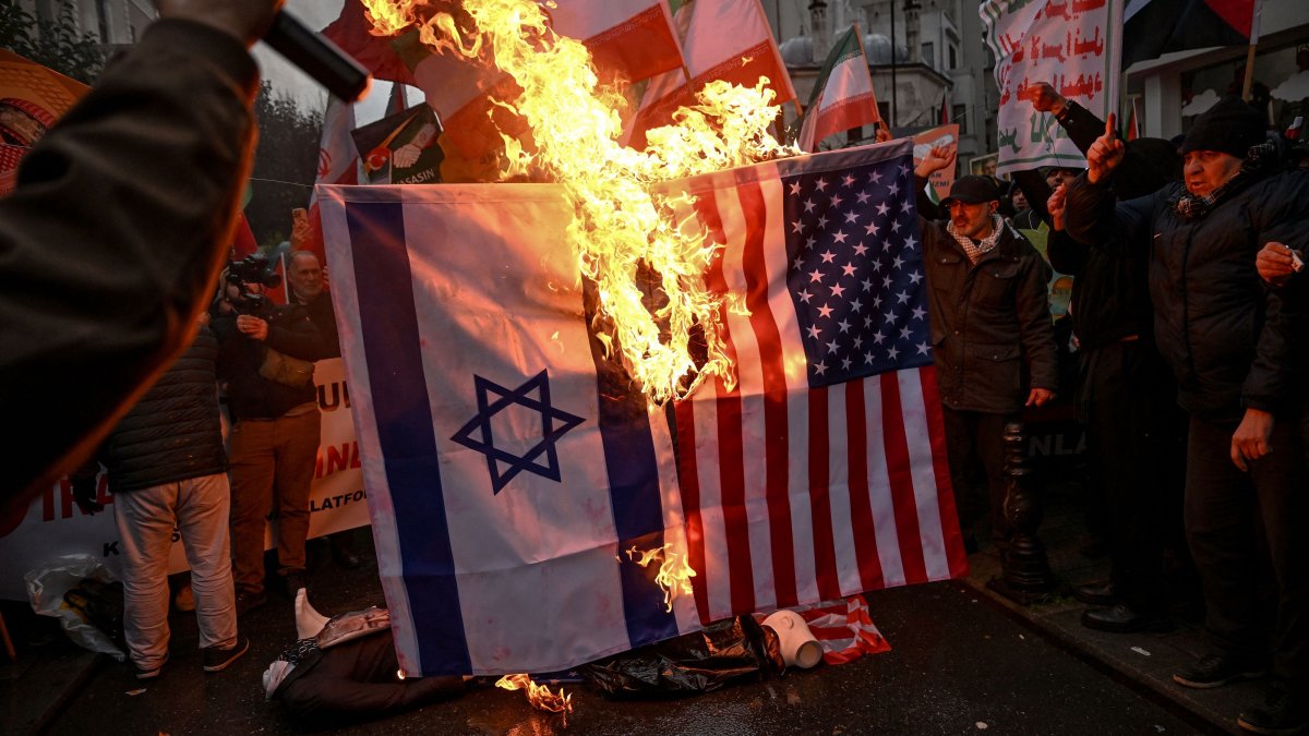Protesters set afire a U.S., Israel national flags as they shout slogans during a pro-Iranian demonstration in front of the Iranian consulate in Istanbul, Türkiye, Jan. 18, 2026. (AFP Photo)
