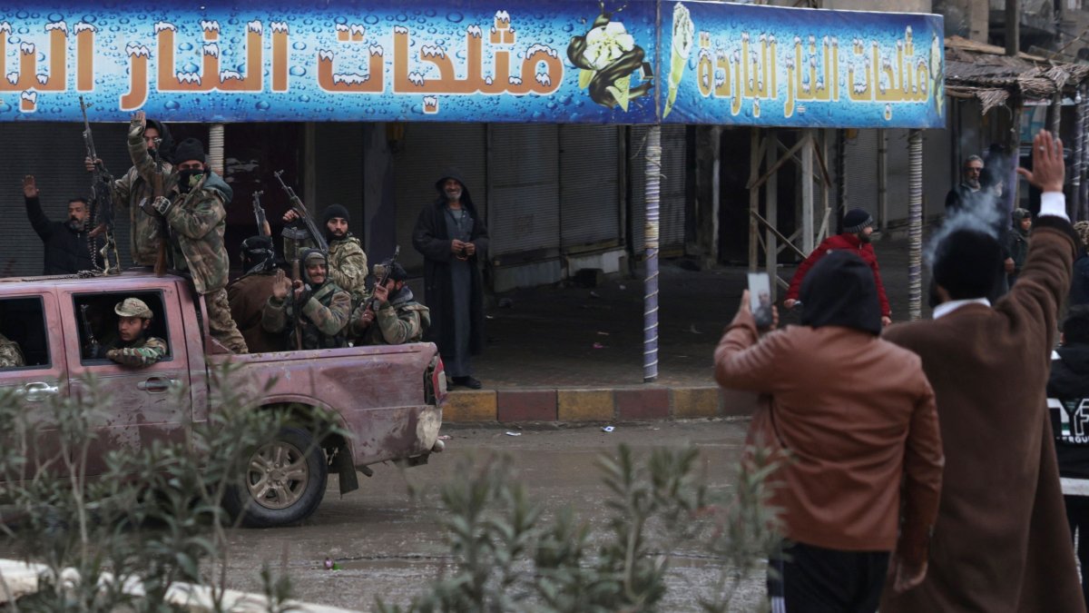 Residents wave as Syrian Ministry of Defense forces drive through the streets of the northern city of Raqqa, on the north bank of the Euphrates River, Syria, Jan. 18, 2026. (AFP Photo)