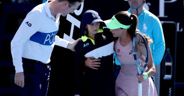 Türkiye's Zeynep Sönmez assists a ball kid after she fainted during Sönmez’s women’s singles match against Russia’s Ekaterina Alexandrova, Melbourne, Australia, Jan. 18, 2026. (AFP Photo)