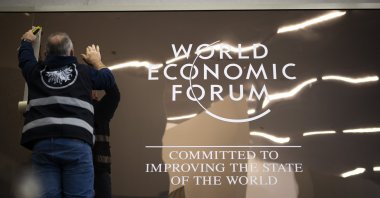 A worker sets up a logo in the Congress Center prior the 56th annual meeting of the World Economic Forum (WEF), Davos, Switzerland, Jan. 18, 2026. (EPA Photo)