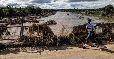A young girl walks across the damaged bridge crossing the Ga-Selati River, just outside Phalaborwa following heavy rains over much of the Limpopo Province, South Africa, Jan. 16, 2026. (AFP Photo)