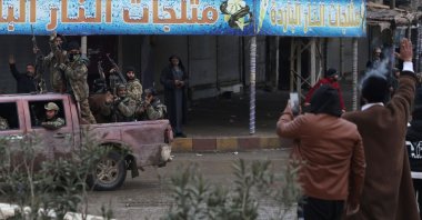 Residents wave as Syrian Ministry of Defense forces drive through the streets of the northern city of Raqqa, on the north bank of the Euphrates River, Syria, Jan. 18, 2026. (AFP Photo)