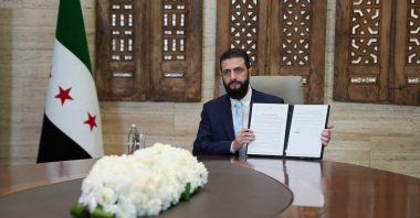 President Ahmed al-Sharaa signs an agreement at the Presidential Palace in Damascus, Syria, Jan. 18, 2026. (AFP Photo)