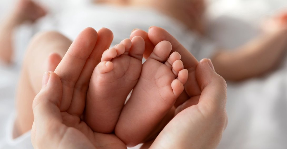 Tiny newborn baby feet gently held in a mother’s hands. (Shutterstock Photo)