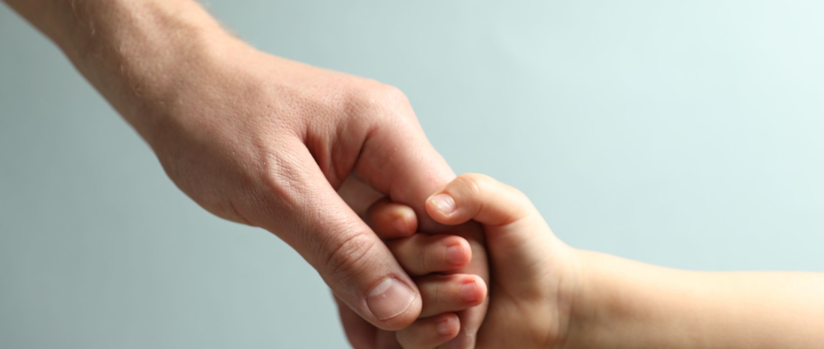 A father and child holding hands. (Shutterstock Photo)