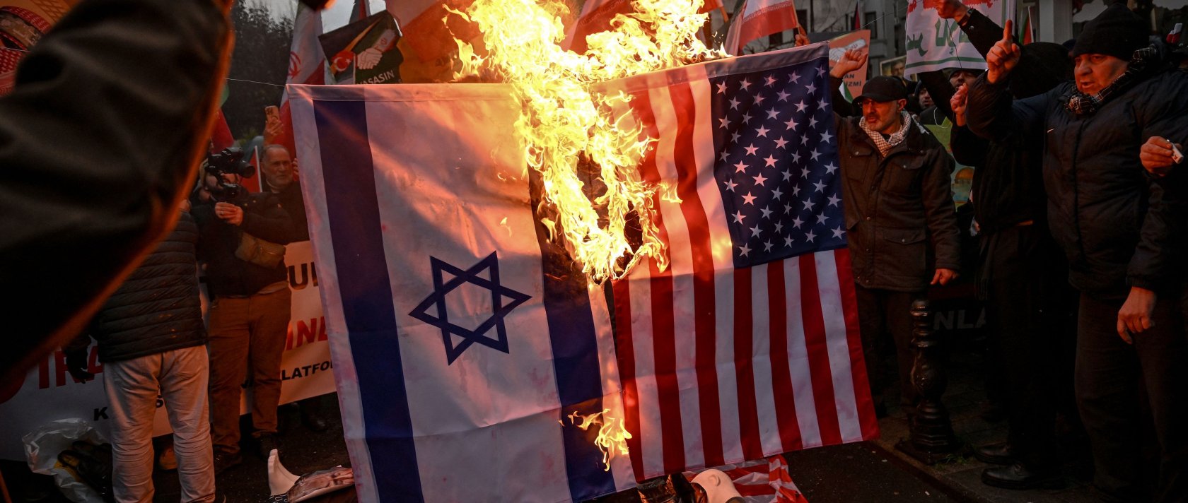 Protesters set afire a U.S., Israel national flags as they shout slogans during a pro-Iranian demonstration in front of the Iranian consulate in Istanbul, Türkiye, Jan. 18, 2026. (AFP Photo)