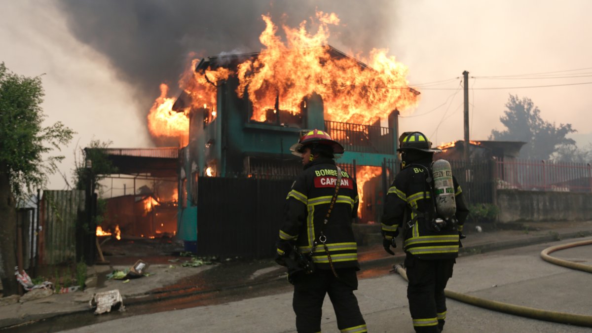 Firefighters work to extinguish a fire in a house affected by wildfires, Penco, Chile, Jan. 18, 2026. (EPA Photo)
