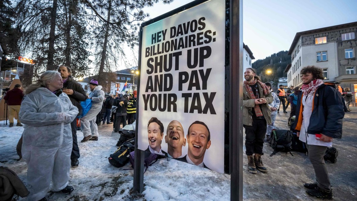 A banner bearing portraits of Elon Musk, Jeff Bezos and Mark Zuckerberg with a slogan is seen during a demonstration against the World Economic Forum (WEF) on the eve of the WEF annual meeting in Davos, Switzerland, Jan. 18, 2026. (AFP Photo)
