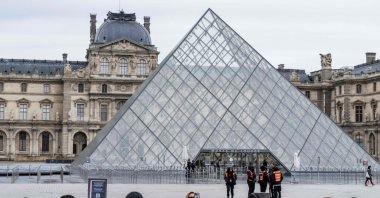 Tourists stand behind barriers blocking the access to the Louvre main courtyard, La Cour Napoleon, with the Louvre Pyramid, designed by Chinese-U.S. architect Ieoh Ming Pei, Paris, France, Jan. 12, 2026. (AFP Photo)